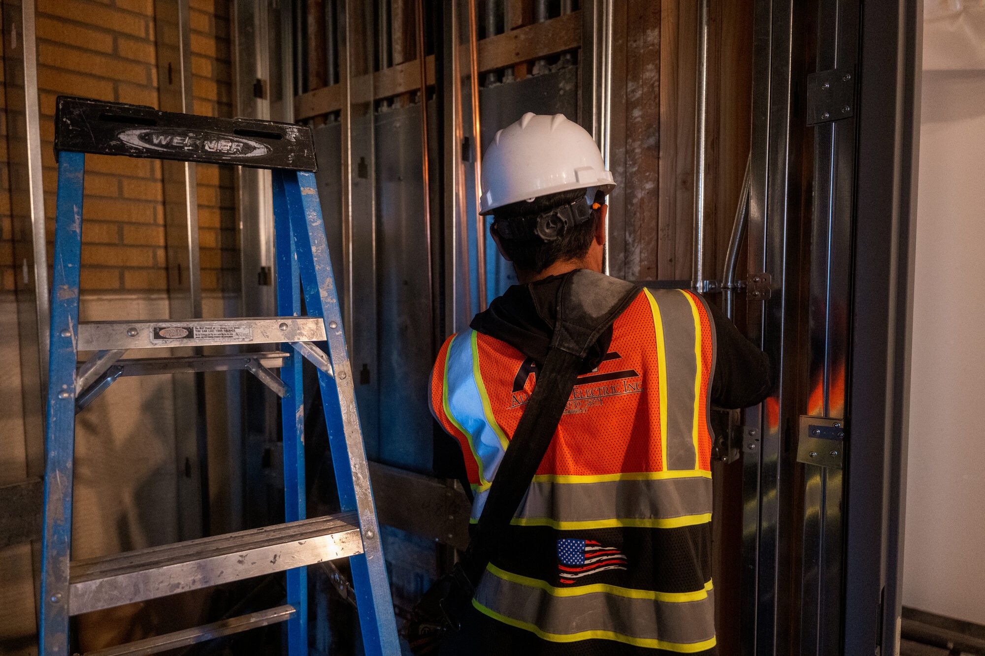 Electrician working from a ladder during the probation facility renovation