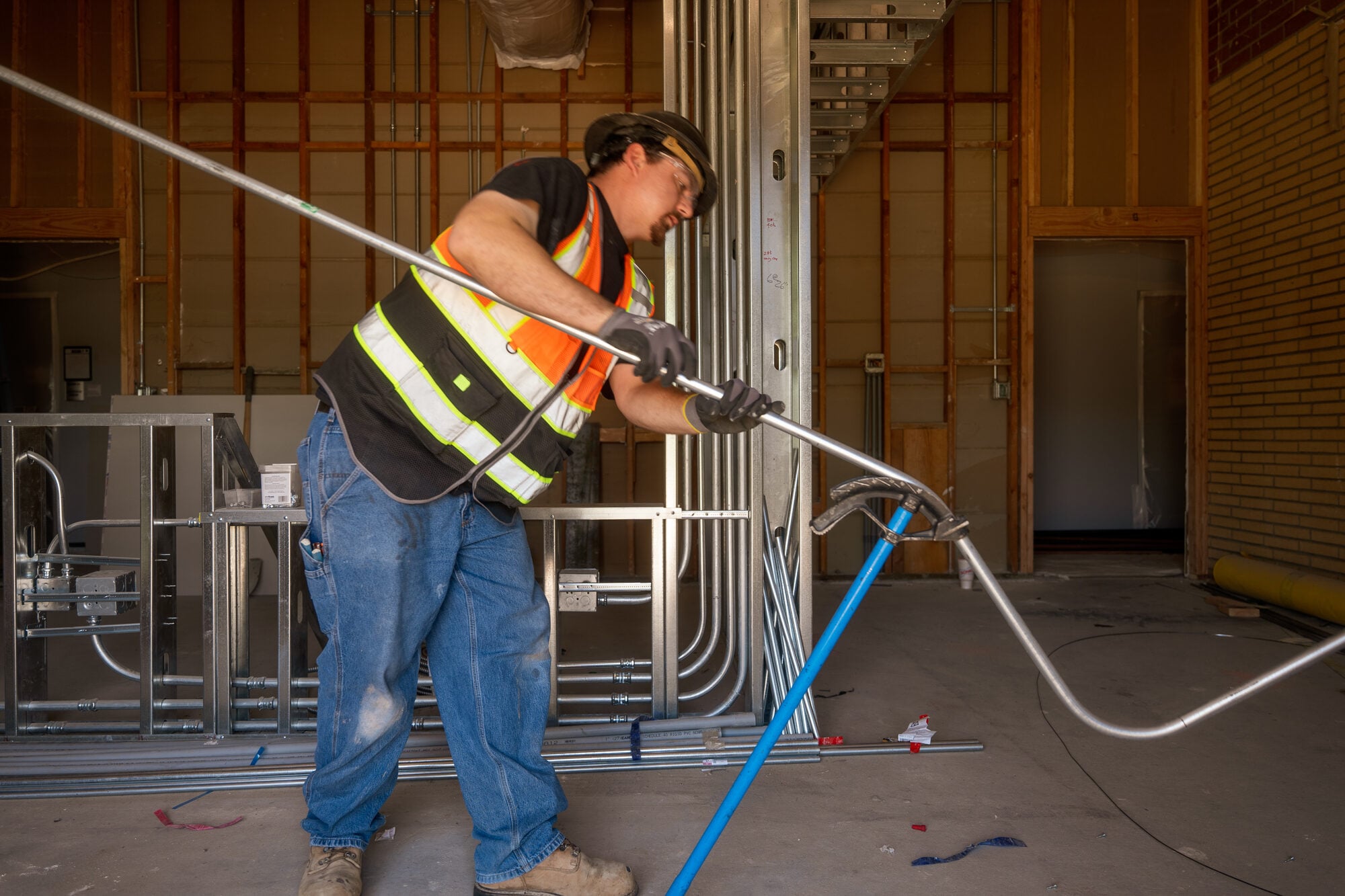 Electrician pulling cable into a metal stud wall on the probation department renovation
